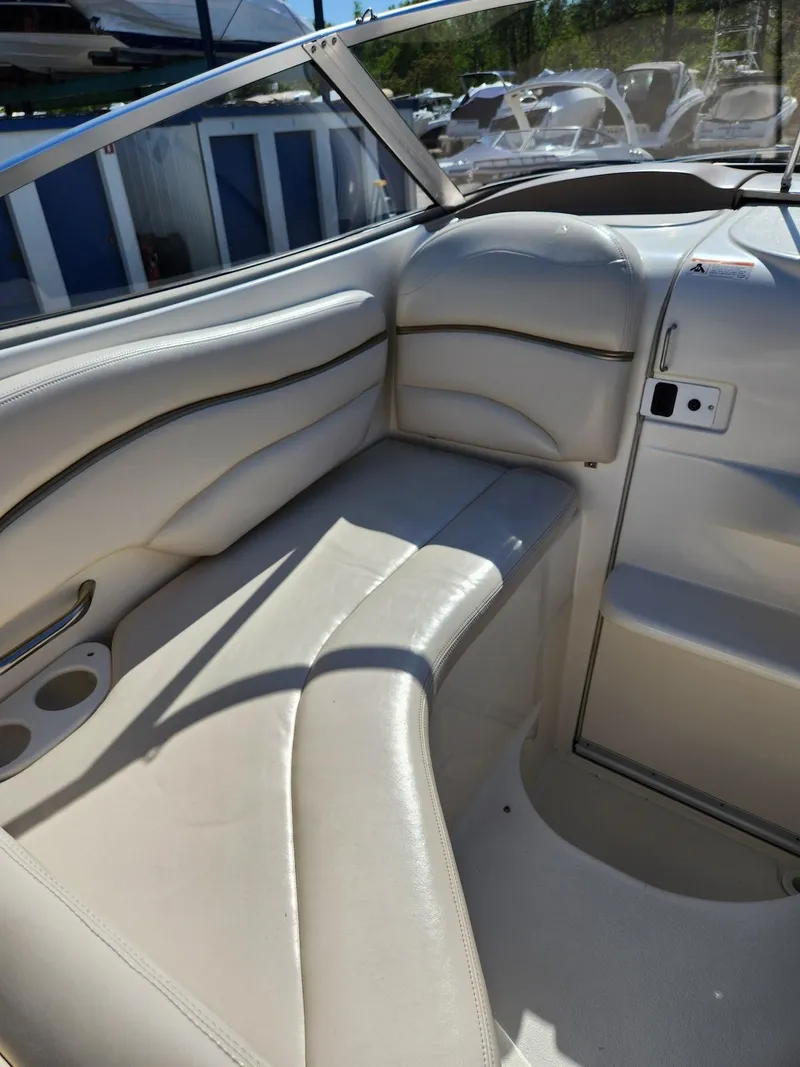 Slide: The Image of 2006 Larson Cabrio 260 boat interior with beige seating and cup holders. - 6