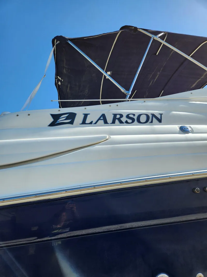 Slide: The Image of 2006 Larson Cabrio 260 boat with canopy, viewed from below against blue sky. - 8