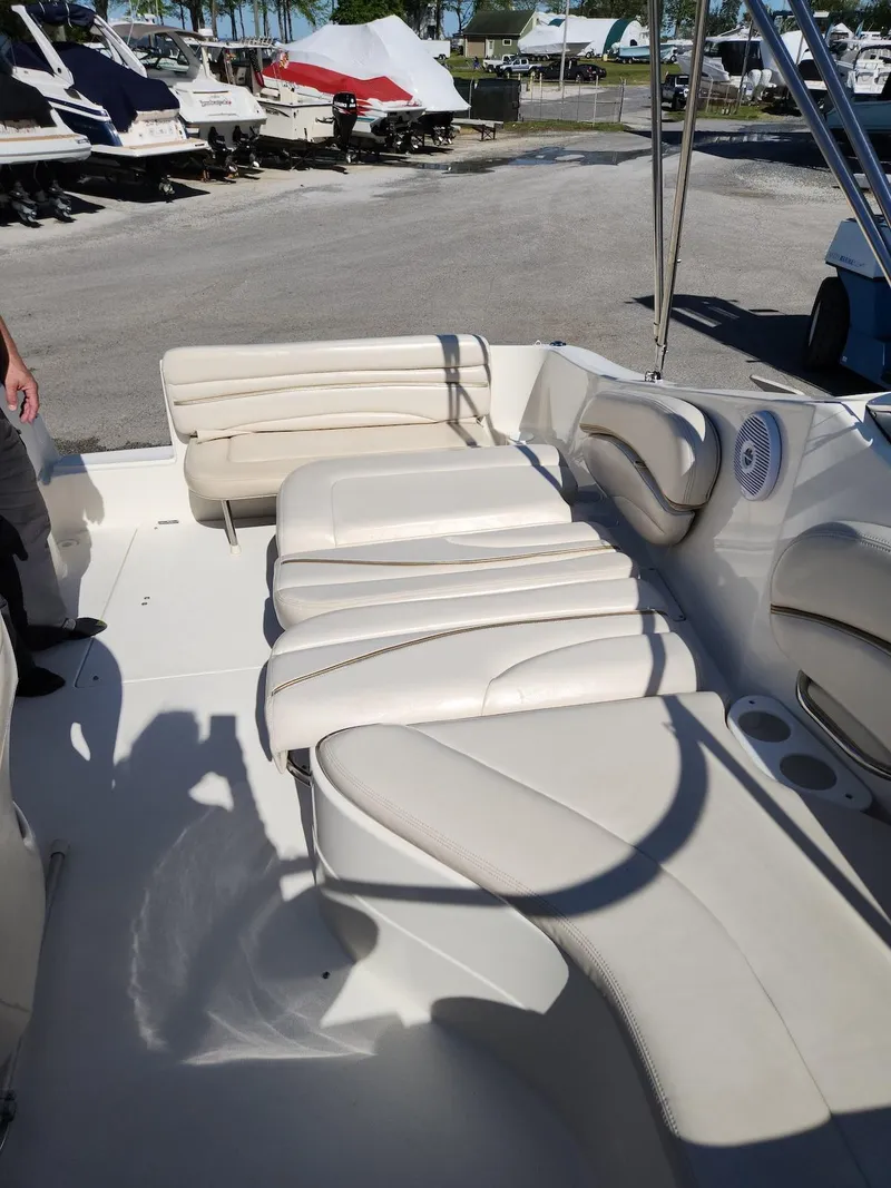 Slide: The Image of 2006 Larson Cabrio 260 boat interior with white seating and cup holders. - 9