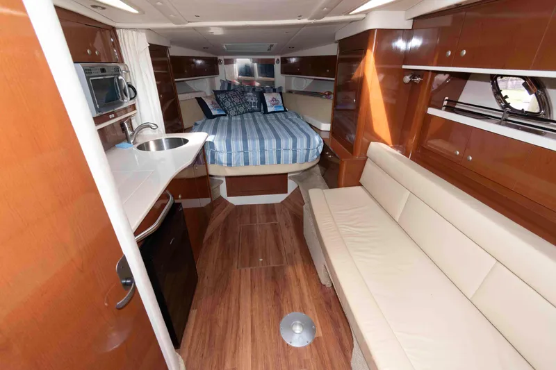 Slide: The Image of Interior of 2008 Sea Ray 330 Sundancer yacht with bed, kitchenette, and seating area. - 15