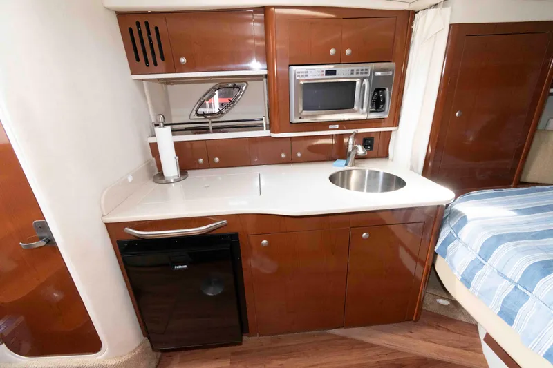 Slide: The Image of 2008 Sea Ray 330 Sundancer galley with microwave, sink, and mini fridge. - 16