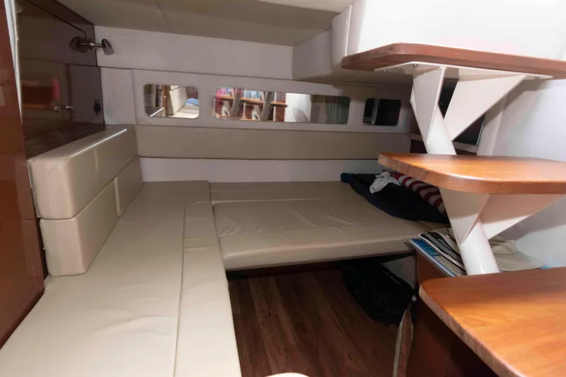 Slide: The Image of 2008 Sea Ray 330 Sundancer cabin interior with beige seating and wooden accents. - 18