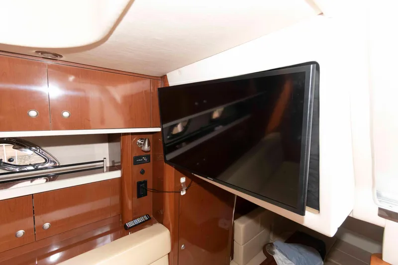 Slide: The Image of Interior of 2008 Sea Ray 330 Sundancer with mounted TV and wooden cabinetry. - 19