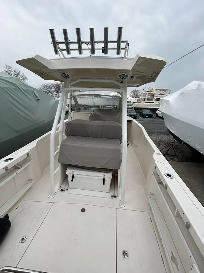 Slide: The Image of 2021 Cutwater C-24 CW boat with covered seating, docked outdoors under cloudy skies. - 5