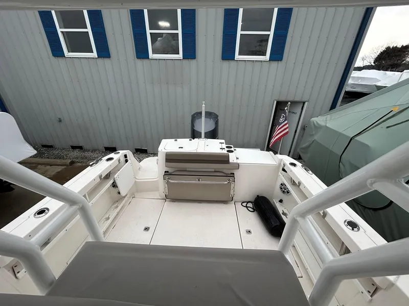 Slide: The Image of 2021 Cutwater C-24 CW boat deck with seating and storage, docked near a building. - 6