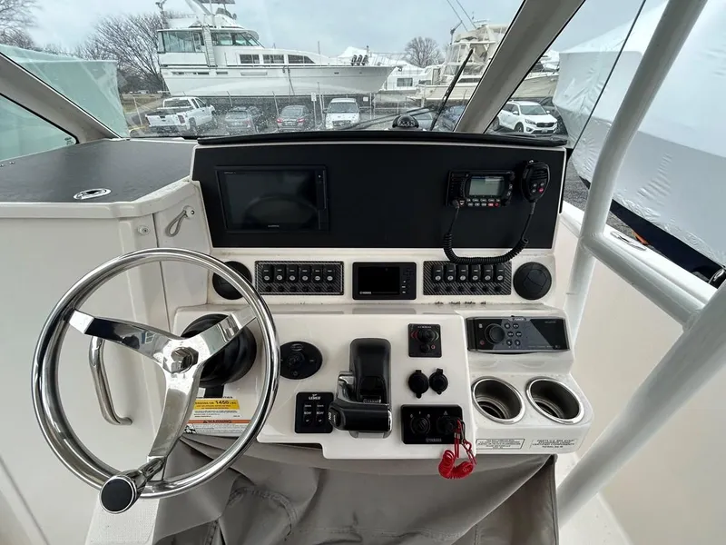 Slide: The Image of 2021 Cutwater C-24 CW helm with steering wheel, controls, and navigation equipment. - 7
