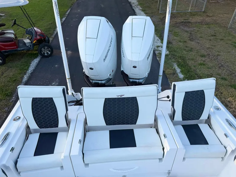 Slide: The Image of 2025 Tidewater 3100 Carolina Bay boat with triple Mercury engines and cushioned seating. - 14