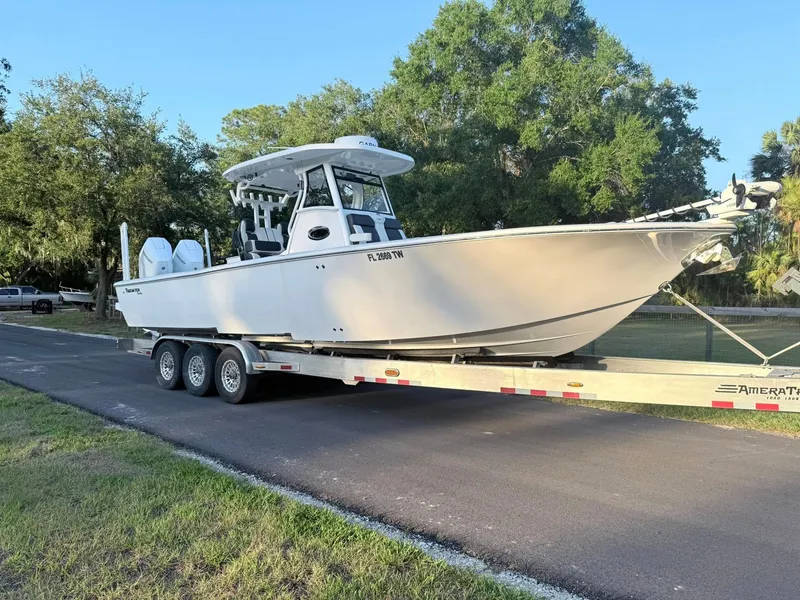 The Image of 2025 Tidewater 3100 Carolina Bay boat on trailer, parked on a road. - 2