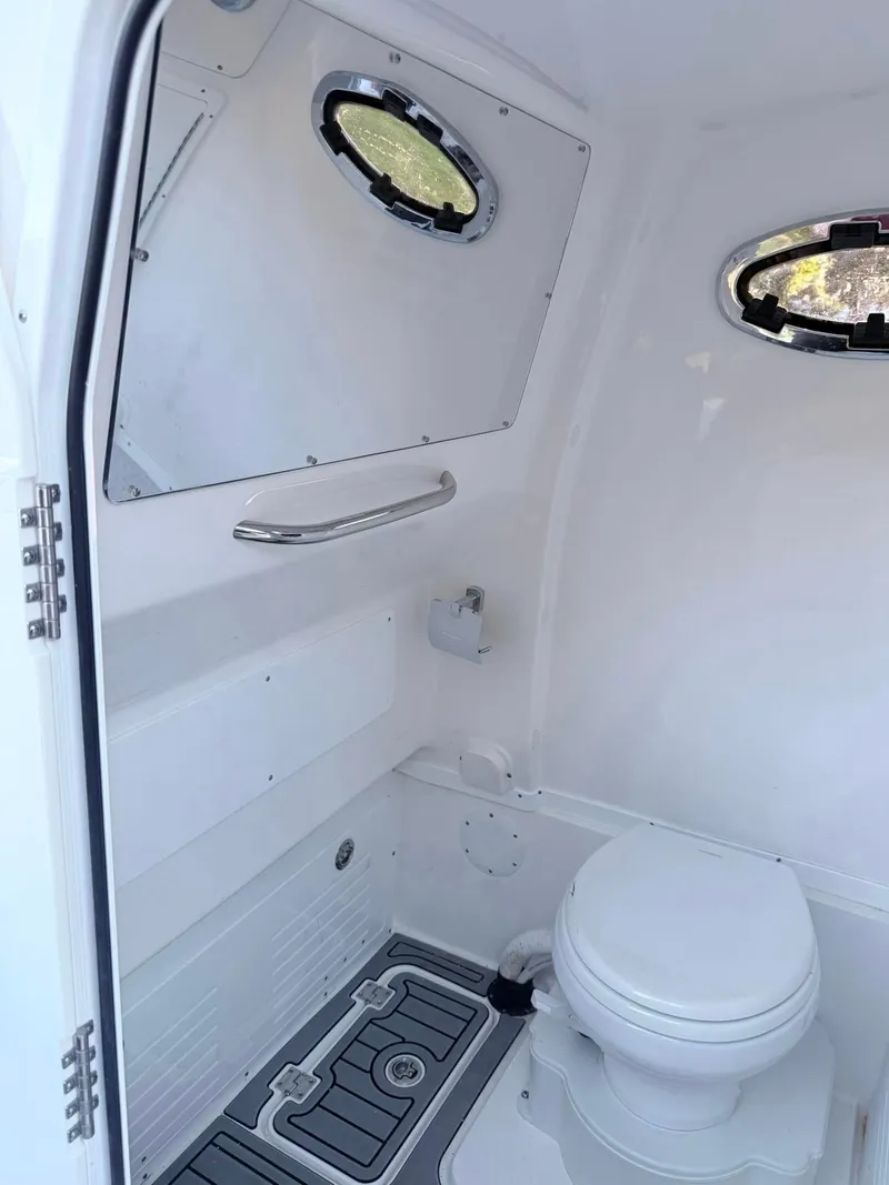 Slide: The Image of 2025 Tidewater 3100 Carolina Bay boat interior with modern marine toilet and portholes. - 20