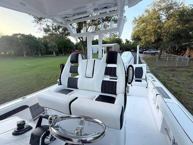 Slide: The Image of 2025 Tidewater 3100 Carolina Bay boat interior with modern seating and steering wheel. - 24