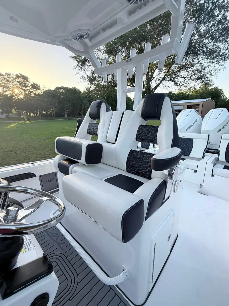 Slide: The Image of 2025 Tidewater 3100 Carolina Bay boat interior with modern seating and steering wheel. - 27