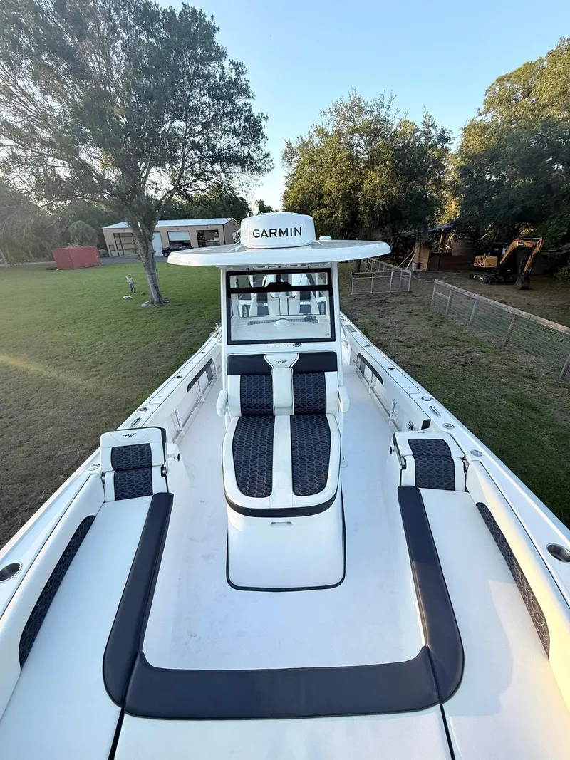 Slide: The Image of 2025 Tidewater 3100 Carolina Bay boat with Garmin equipment, docked in a grassy area. - 37