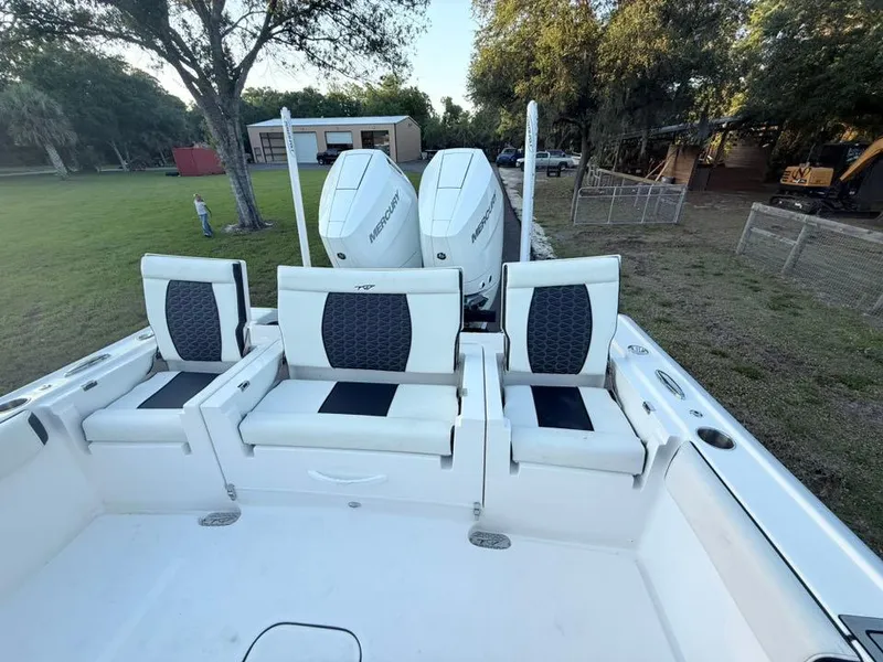 Slide: The Image of 2025 Tidewater 3100 Carolina Bay boat with three cushioned seats and dual outboard motors. - 38