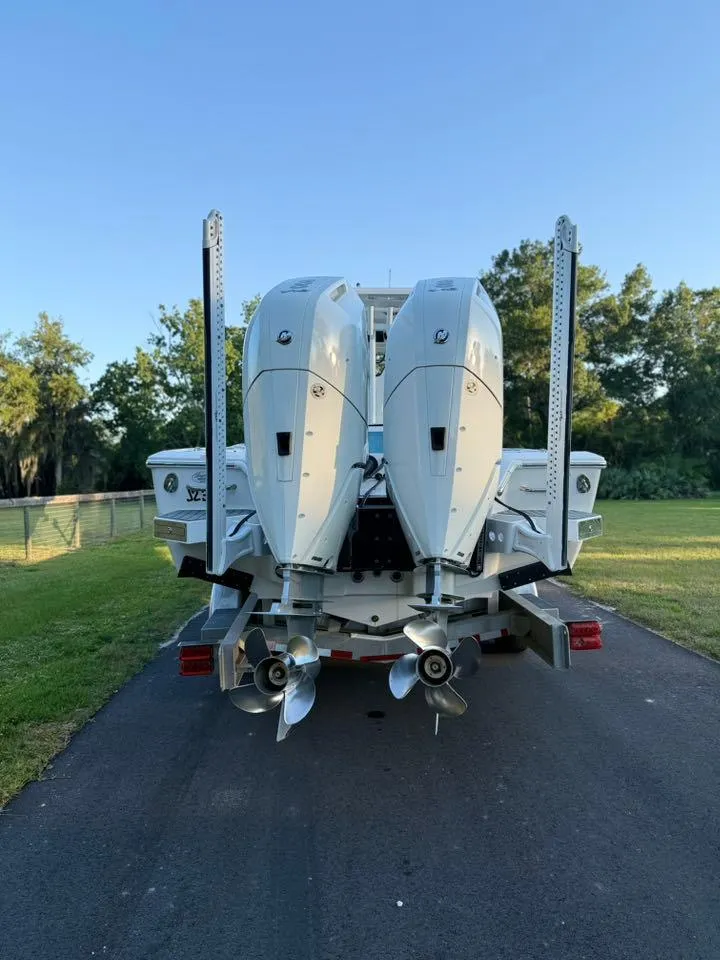 Slide: The Image of 2025 Tidewater 3100 Carolina Bay boat with dual outboard engines on a trailer. - 4