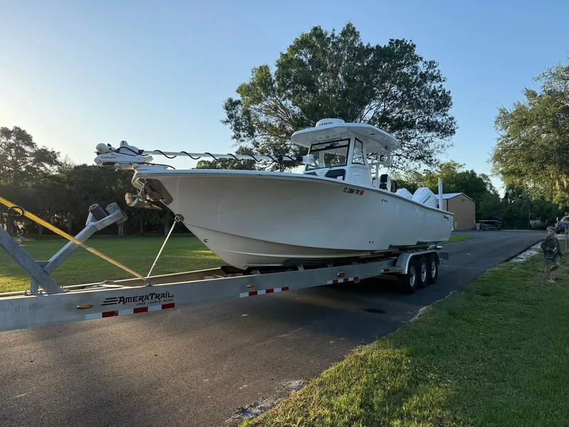 Slide: The Image of 2025 Tidewater 3100 Carolina Bay boat on trailer, parked on a sunny street. - 7