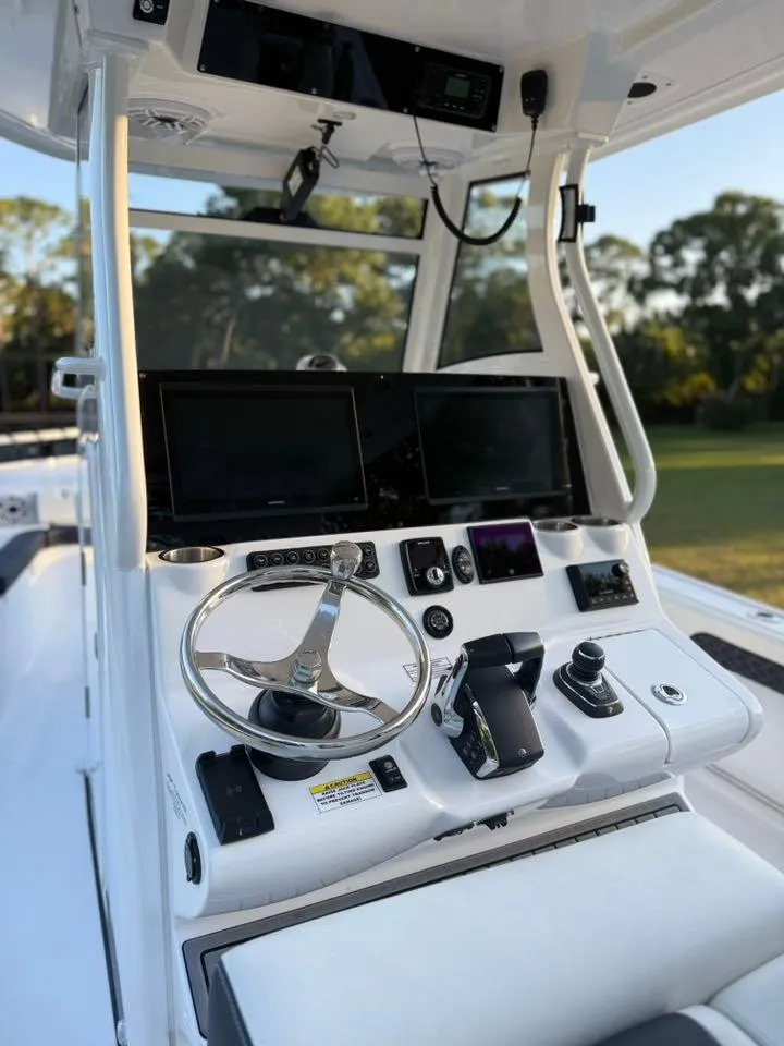 Slide: The Image of 2025 Tidewater 3100 Carolina Bay boat console with modern controls and dual screens. - 9