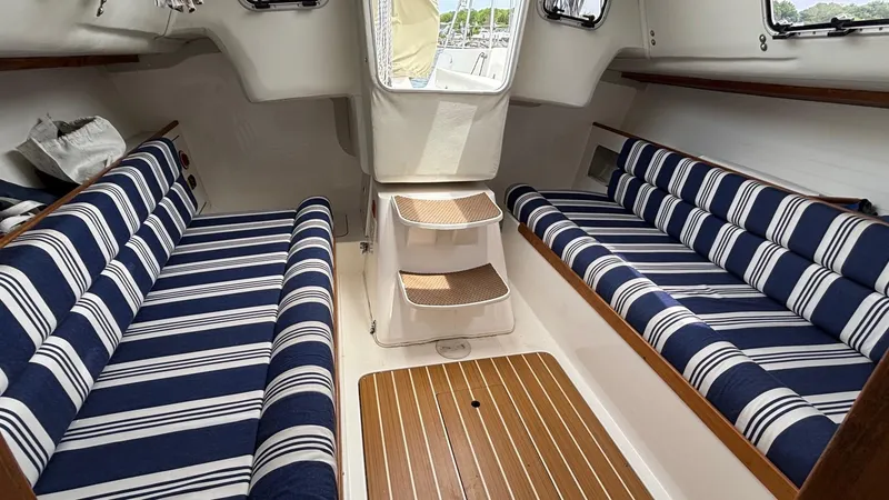 Slide: The Image of Interior of 2012 J Boats J/95 sailboat with striped seating and wooden flooring. - 30