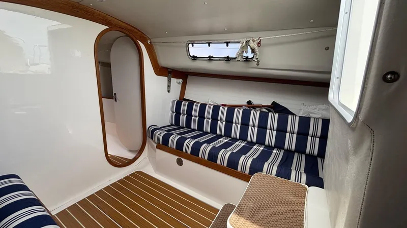 Slide: The Image of Interior of 2012 J Boats J/95 sailboat with striped seating and wooden accents. - 32