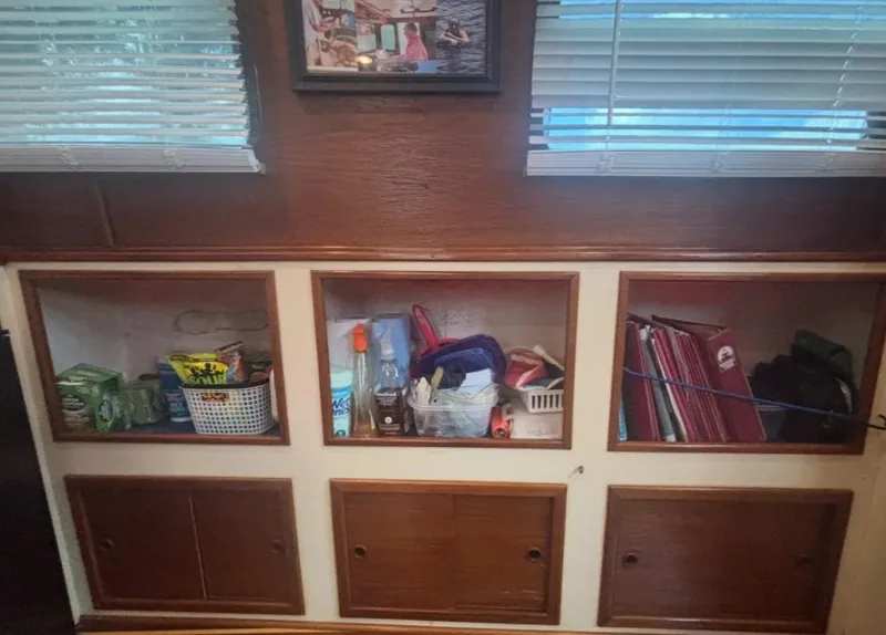 Slide: The Image of Interior storage shelves on a 1985 Nordic Tug 32 boat, featuring organized supplies and decor. - 16