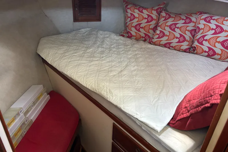 Slide: The Image of Cozy cabin bed in 1985 Nordic Tug 32 with colorful pillows and storage. - 20