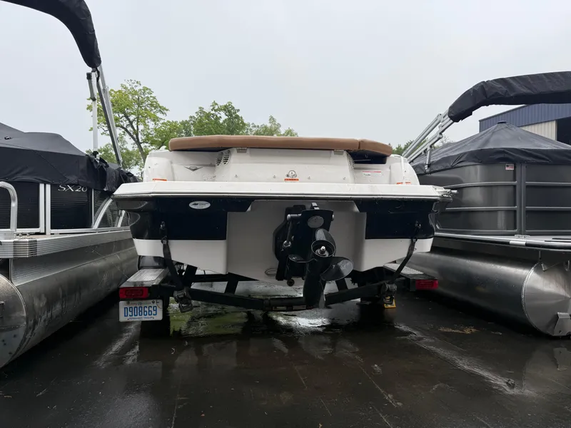Slide: The Image of 2017 Glastron 205 boat on trailer, parked between pontoons, rear view. - 7