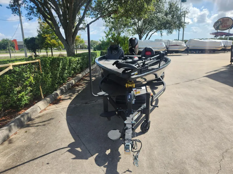 Slide: The Image of 2025 Tracker Savage 215 boat on trailer in sunny outdoor setting. - 2