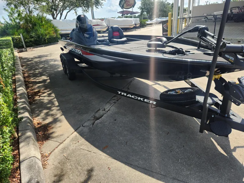 Slide: The Image of 2025 Tracker Savage 215 boat parked on a sunny day, showcasing sleek design and modern features. - 4