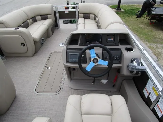 Slide: The Image of 2025 Sun Tracker SportFish 22 XP3 boat interior with beige seating and modern steering console. - 3