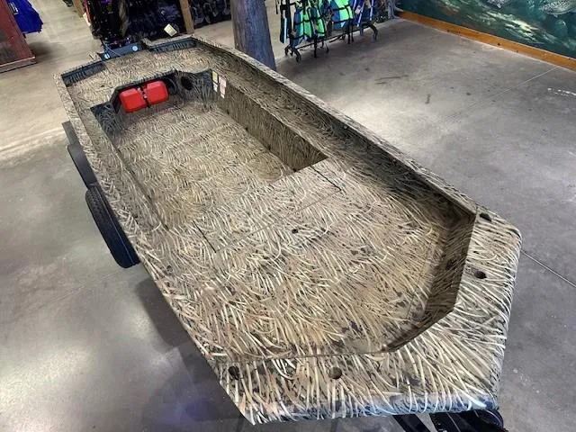 Slide: The Image of 2025 Tracker Grizzly 1650 T Prairie Wings Edition boat with camouflage design in a showroom. - 5