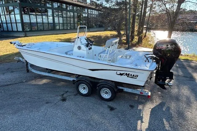 The Image of 2024 Mako Pro Skiff 19 CC boat on trailer by a lake. - 0