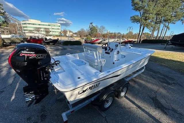 Slide: The Image of 2024 Mako Pro Skiff 19 CC boat on trailer with Mercury engine, parked outdoors. - 5