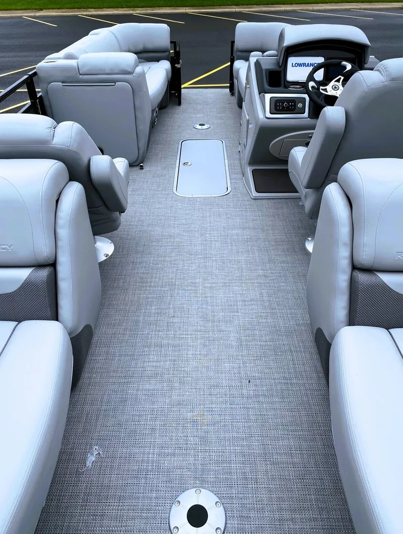 Slide: The Image of Interior of 2025 Regency 230 DL3 boat with gray seating and modern dashboard. - 2
