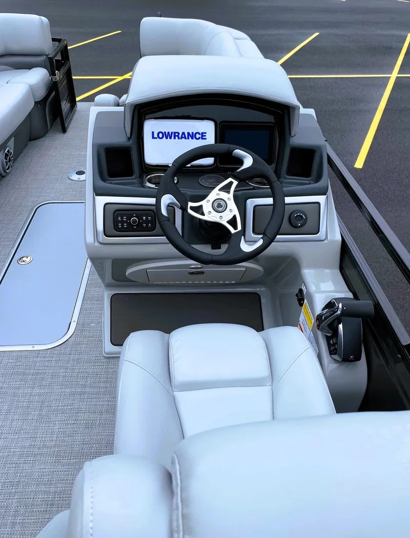 Slide: The Image of 2025 Regency 230 DL3 boat cockpit with steering wheel and Lowrance display. - 3