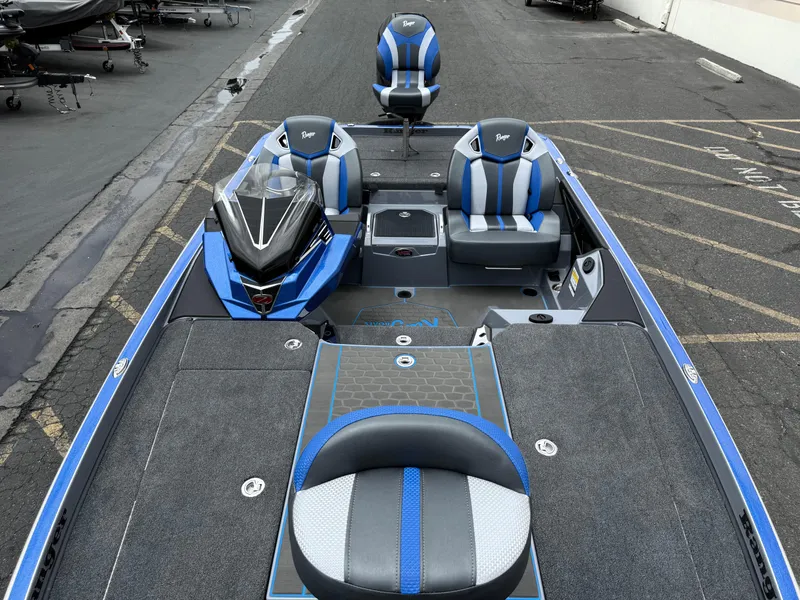 Slide: The Image of 2025 Ranger Z520R Cup-Equipped boat with blue and gray seating, parked on asphalt. - 10
