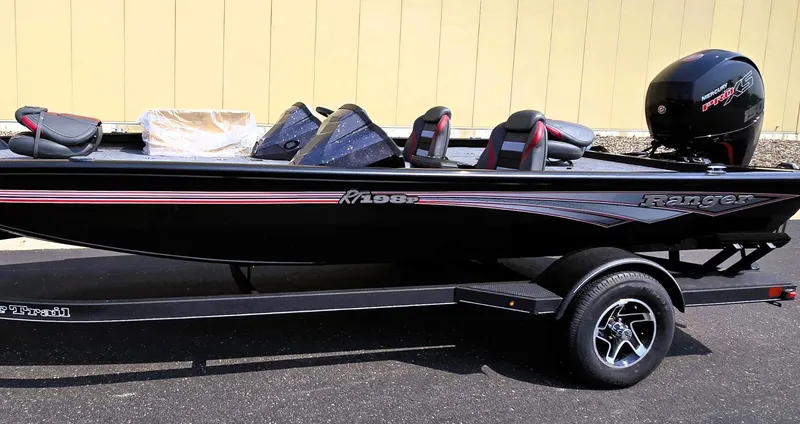 The Image of 2025 Ranger RT198P fishing boat on trailer, black with red accents, side view. - 0
