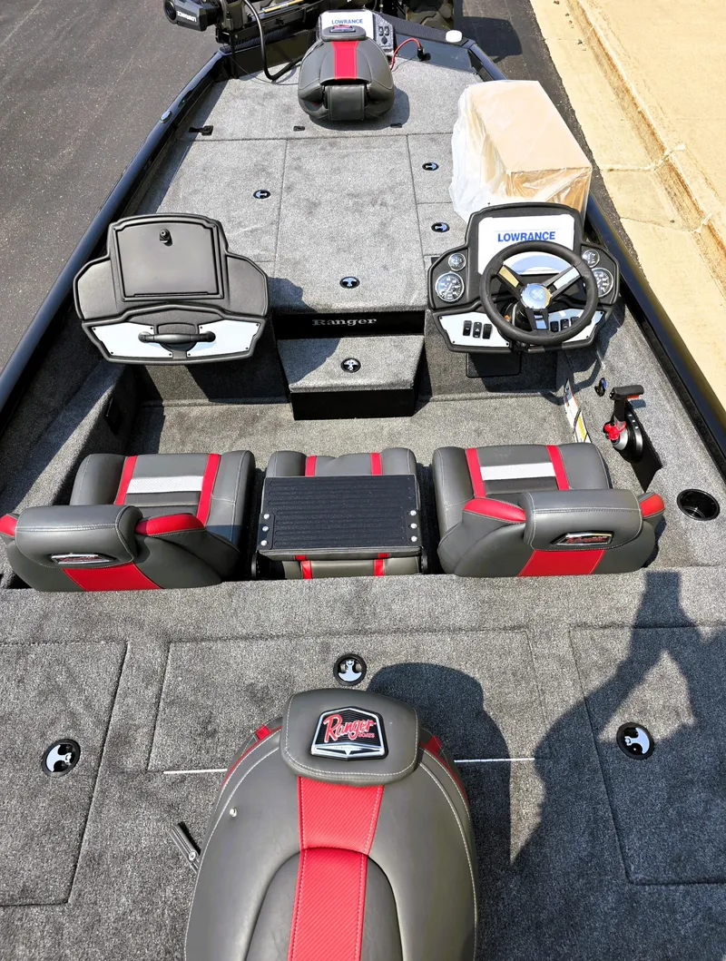 Slide: The Image of 2025 Ranger RT198P boat interior with red and gray seats, steering console, and storage compartments. - 2