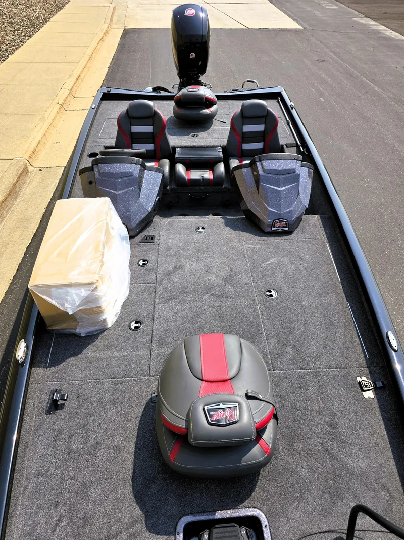 Slide: The Image of 2025 Ranger RT198P boat interior with seating and storage on a paved surface. - 3