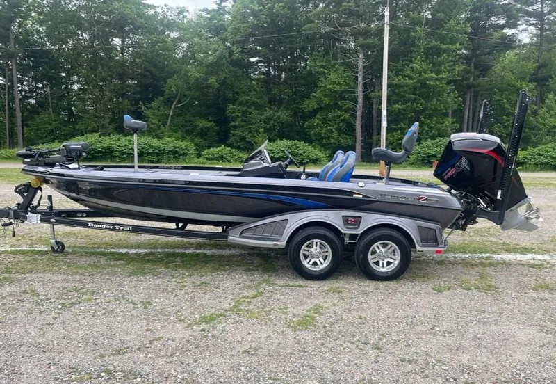 The Image of 2025 Ranger Z520R boat on trailer, parked outdoors with lush green trees in background. - 0