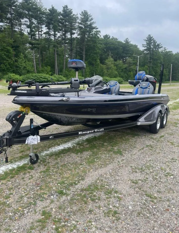 Slide: The Image of 2025 Ranger Z520R boat on trailer, parked outdoors with trees in background. - 2