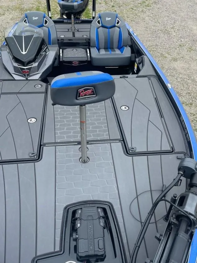 Slide: The Image of 2025 Ranger Z520R boat interior with blue and black seating, advanced dashboard, and spacious deck. - 4