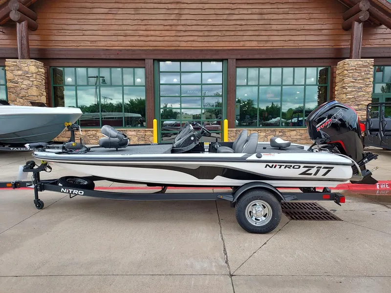 The Image of 2025 Nitro Z17 boat on trailer, parked outside a rustic building. - 0