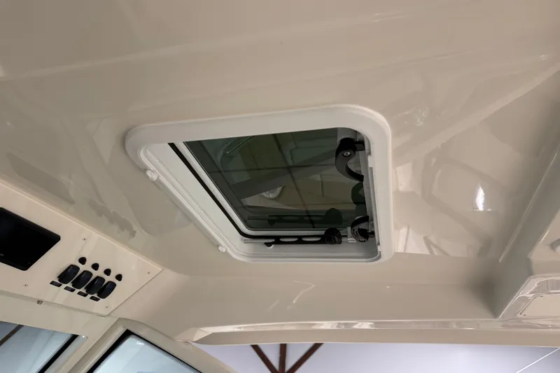 Slide: The Image of 2026 Sailfish 316 DC boat interior with a ceiling hatch and control panel. - 17