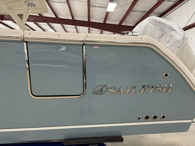 Slide: The Image of 2026 Sailfish 316 DC boat side view in a warehouse setting. - 3