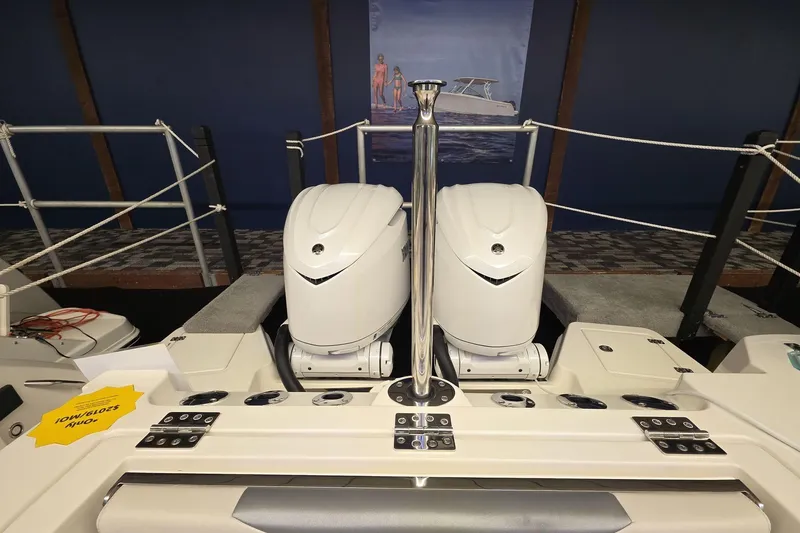 Slide: The Image of 2026 Sailfish 316 DC boat with dual outboard engines displayed indoors. - 39