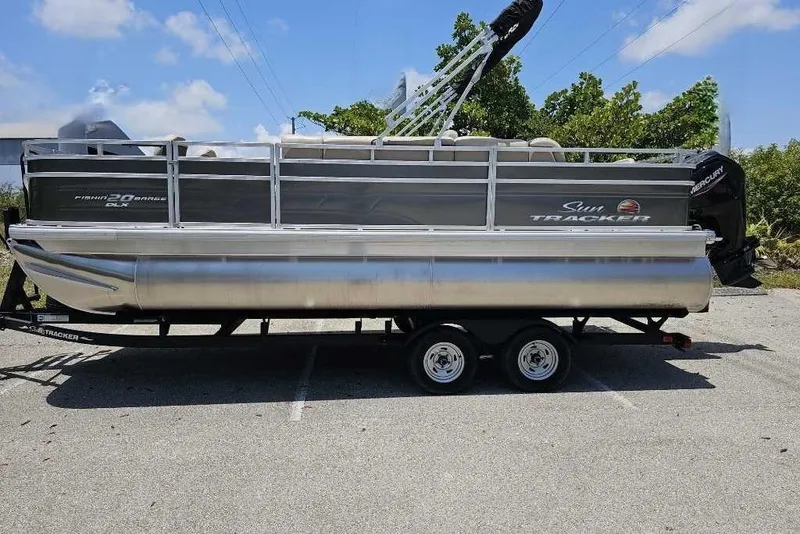 The Image of 2025 Sun Tracker SportFish 20 DLX pontoon boat on trailer, parked outdoors. - 0