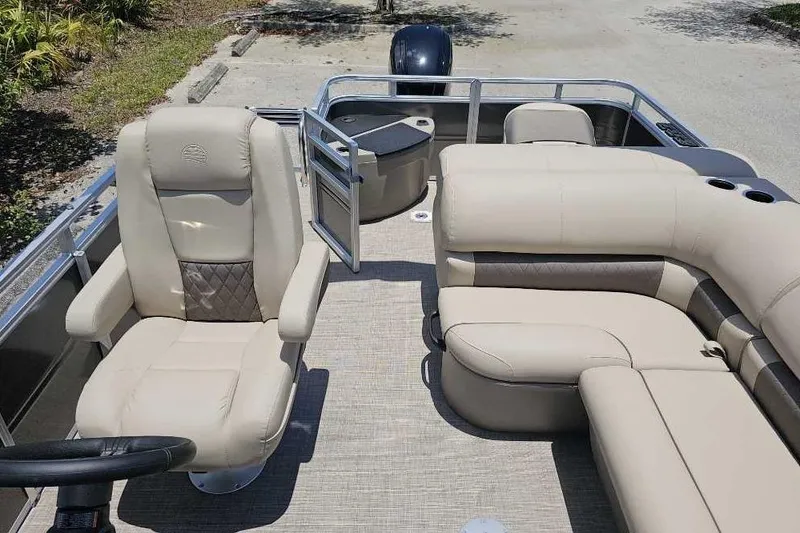 Slide: The Image of 2025 Sun Tracker SportFish 20 DLX pontoon boat with beige seating and steering wheel. - 3