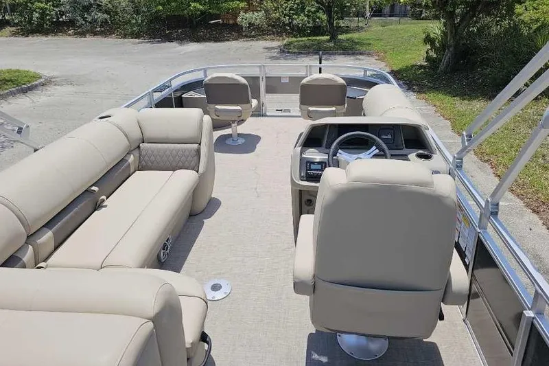 Slide: The Image of 2025 Sun Tracker SportFish 20 DLX pontoon boat interior with beige seating and steering console. - 4