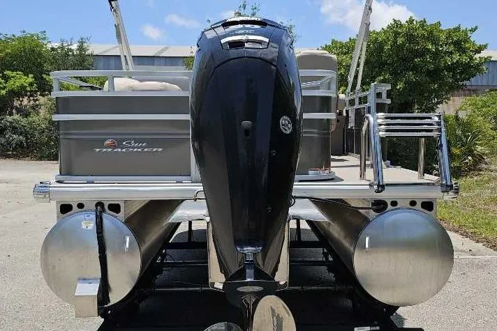 Slide: The Image of 2025 Sun Tracker SportFish 20 DLX pontoon boat with powerful outboard motor, parked outdoors. - 6