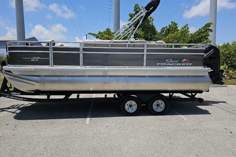 Slide: The Image of 2025 Sun Tracker SportFish 20 DLX pontoon boat on trailer, parked outdoors. - 88