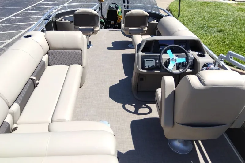 Slide: The Image of 2025 Sun Tracker Fishin' Barge 20 DLX interior with beige seating and modern helm. - 8